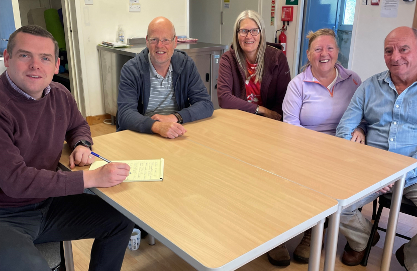 Douglas sits round a table with residents of Roseisle