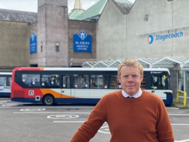 Tim Eagle standing infront of a bus