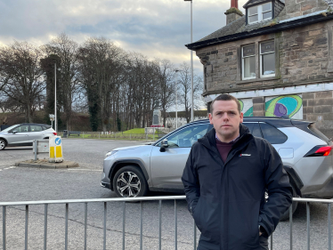 Douglas stands infront of the problematic roundabout junction as a car passes