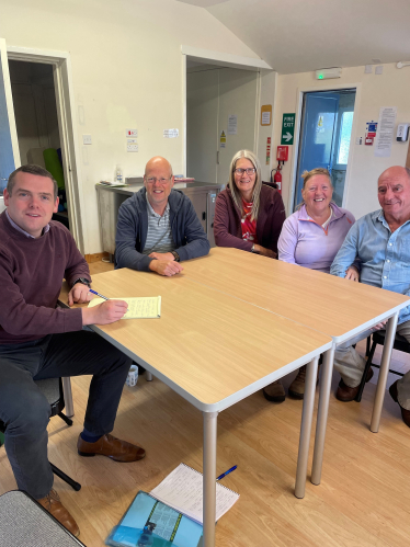 Douglas sits round a table with residents of Roseisle